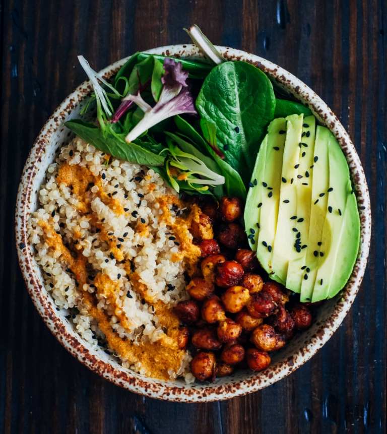 Kichererbsen, Salatmix, Quinoa und Avocado als Zutaten für die Bowl und Sesamsamen als Topping