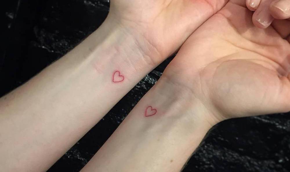 Micro-Tattoo mit roten Herzen auf dem Handgelenk als Idee für Partnertattoos