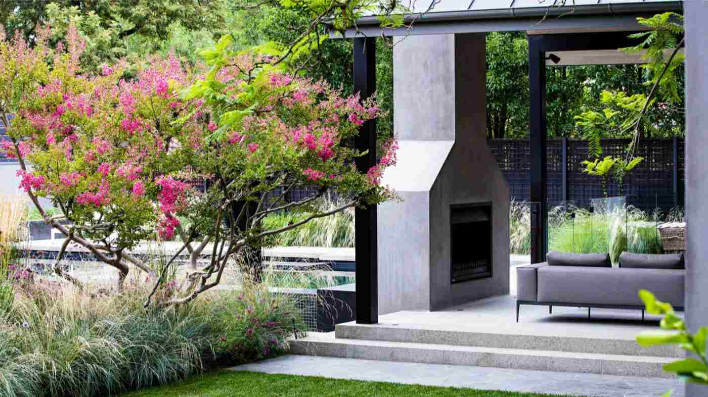 Modern und romantisch zugleich ist dieser Beton Kamin auf einer Terrasse mit Überdachung