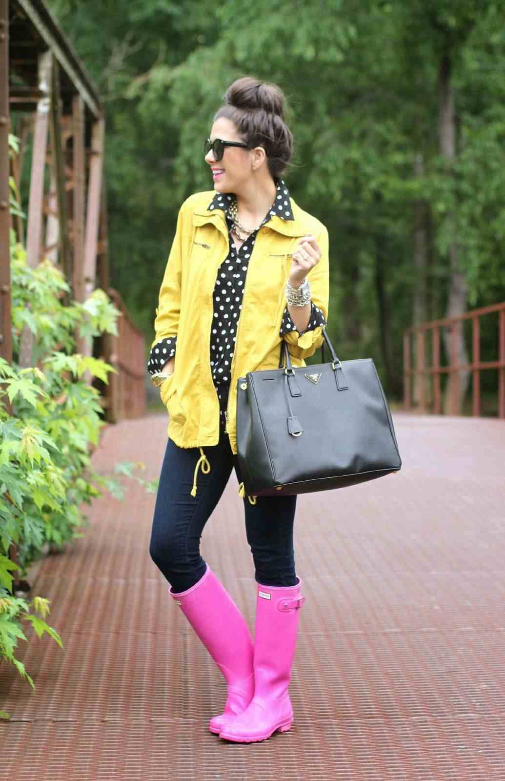 Regenjacke in Gelb, gepunktete Bluse, rosa Gummistiefel und enge Jeans