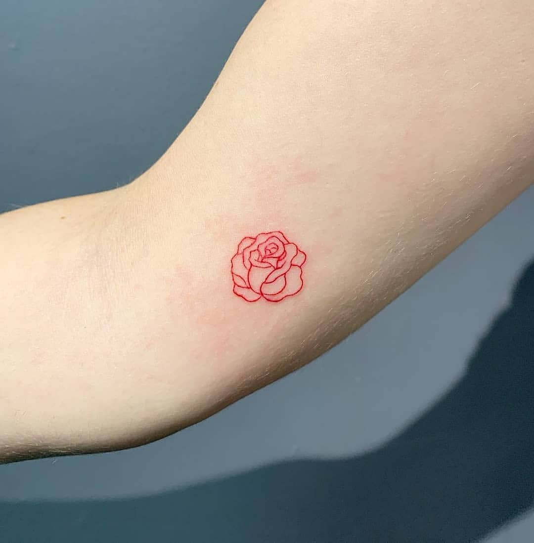 Rose in Rot als Minitattoo auf dem Arm mit abstraktem Look