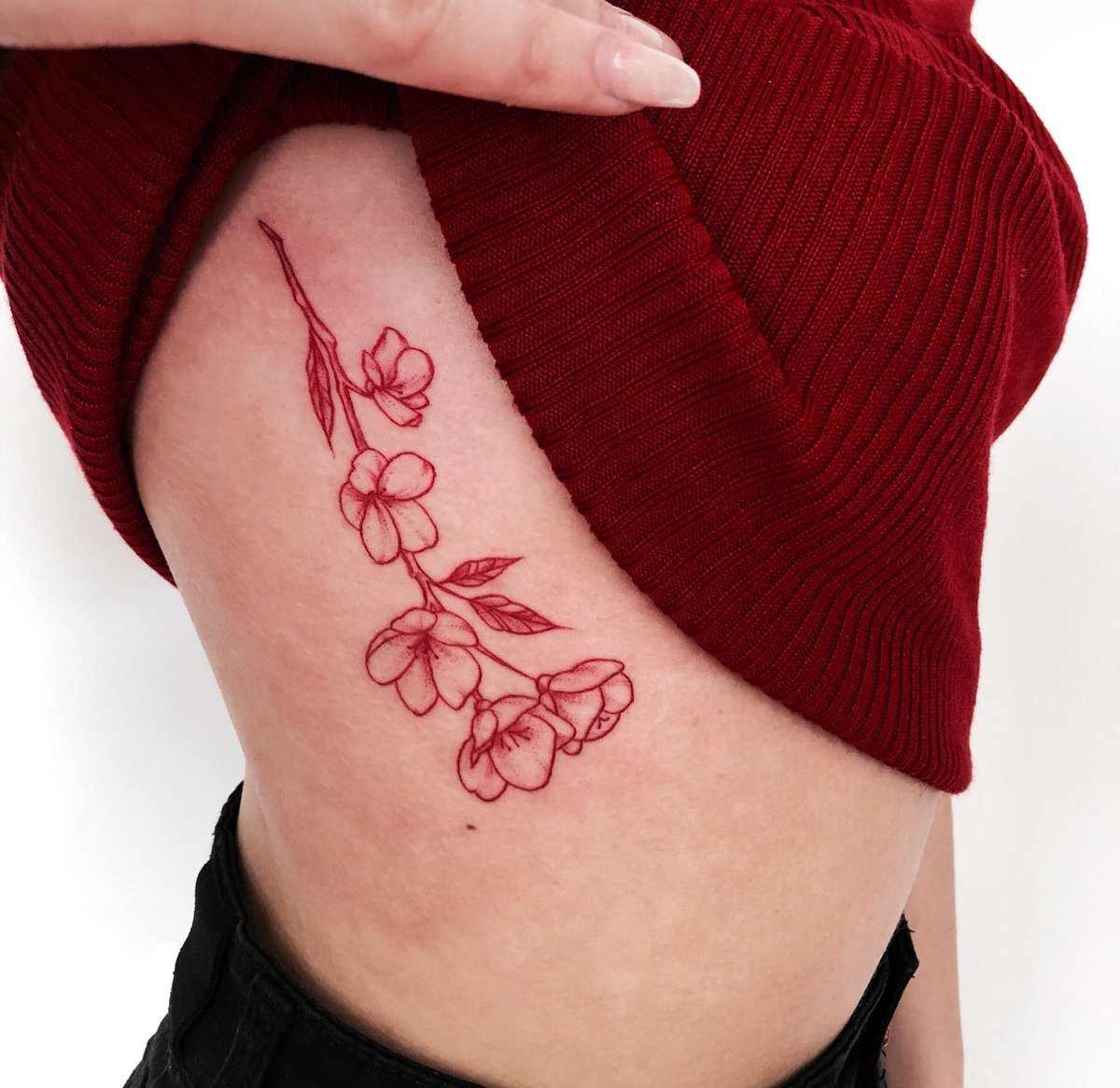 Rote Tattoos für Damen mit Blumen auf dem Brustkorb