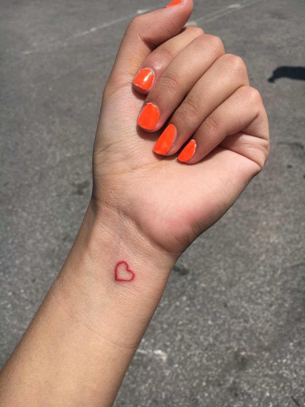 Rote Tattoos im Kleinformat mit Idee für ein Herz auf dem Handgelenk