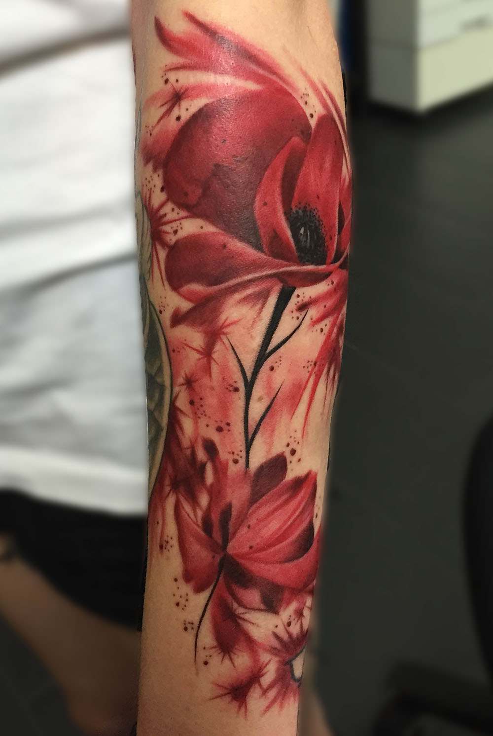 Rote Tattoos mit Aquarell-Effekt für Blumen auf dem Arm