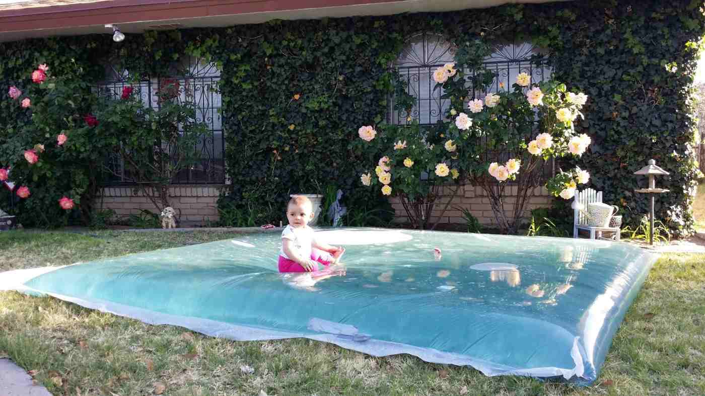 Spielen mit Kindern im Garten auf einem selbstgemachten Wasserkissen
