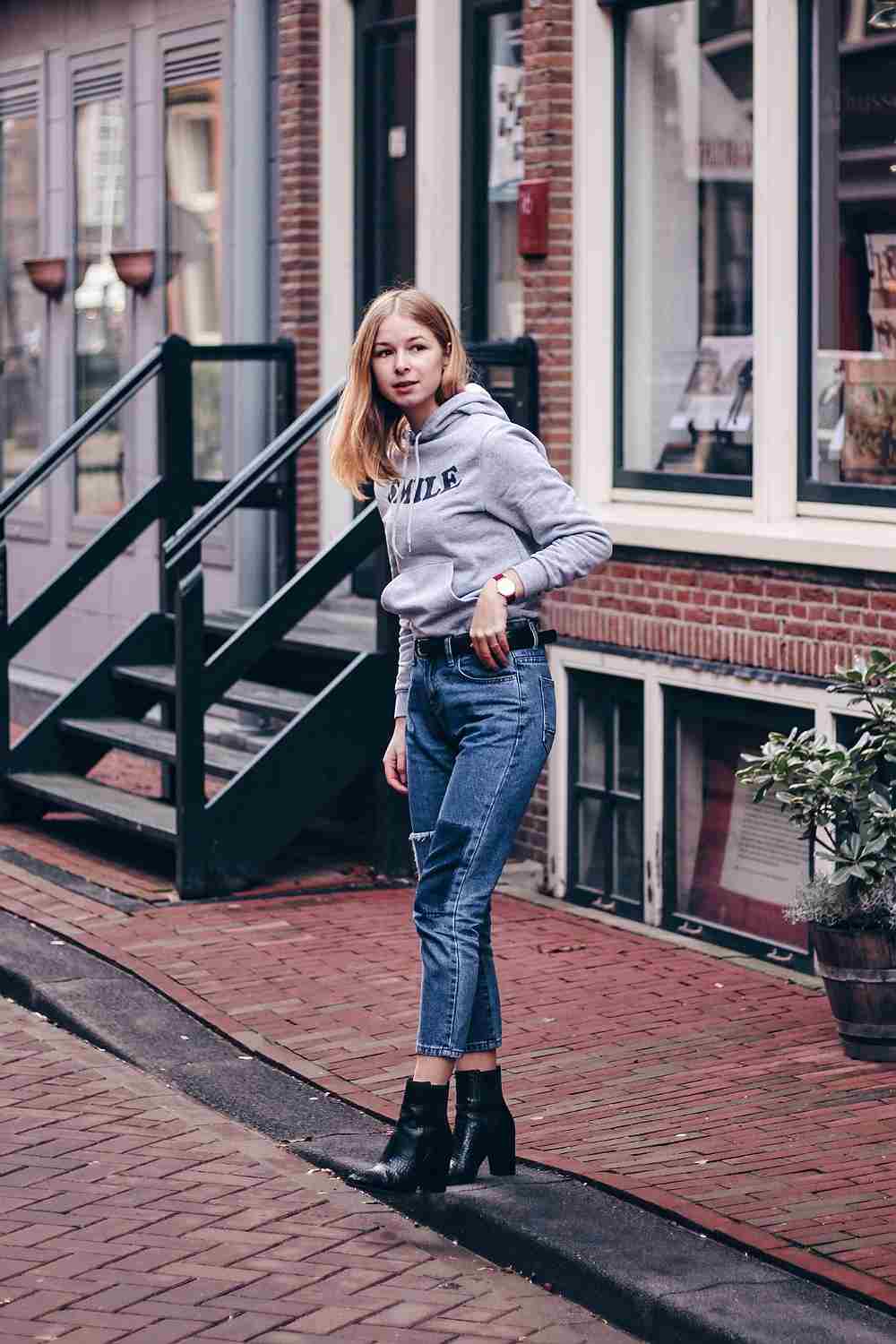 Sportlicher Hoodie als Regenbekleidung für Damen mit Jeans und Stiefeletten kombiniert