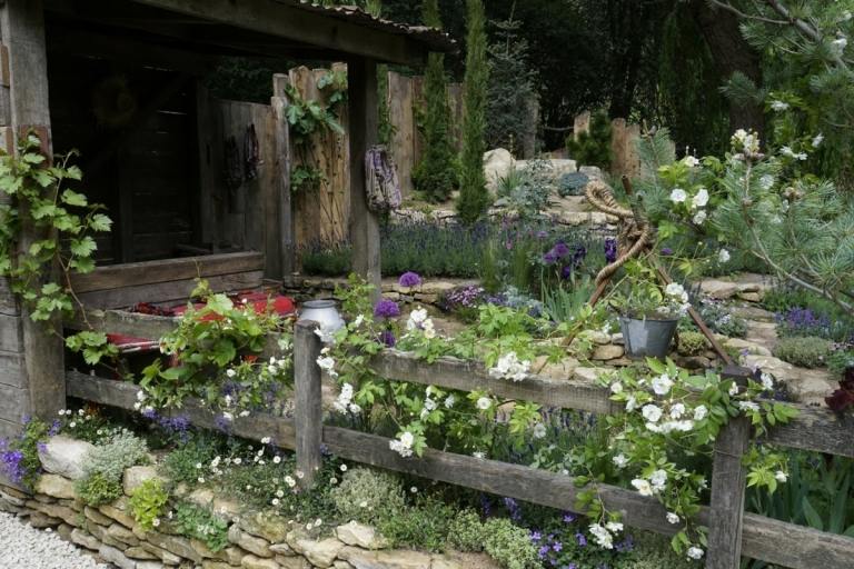 Stein und Holz im Cottage-Garten einsetzen und nach Belieben Pflanzen verwenden