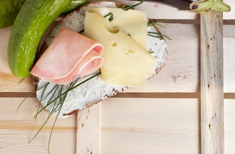 brot mit frischkäse schinken und lauchzwiebeln neben gurke