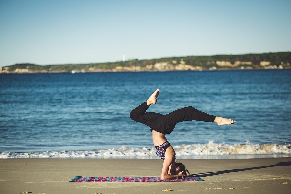 frau macht yoga am strand während des tages am meer