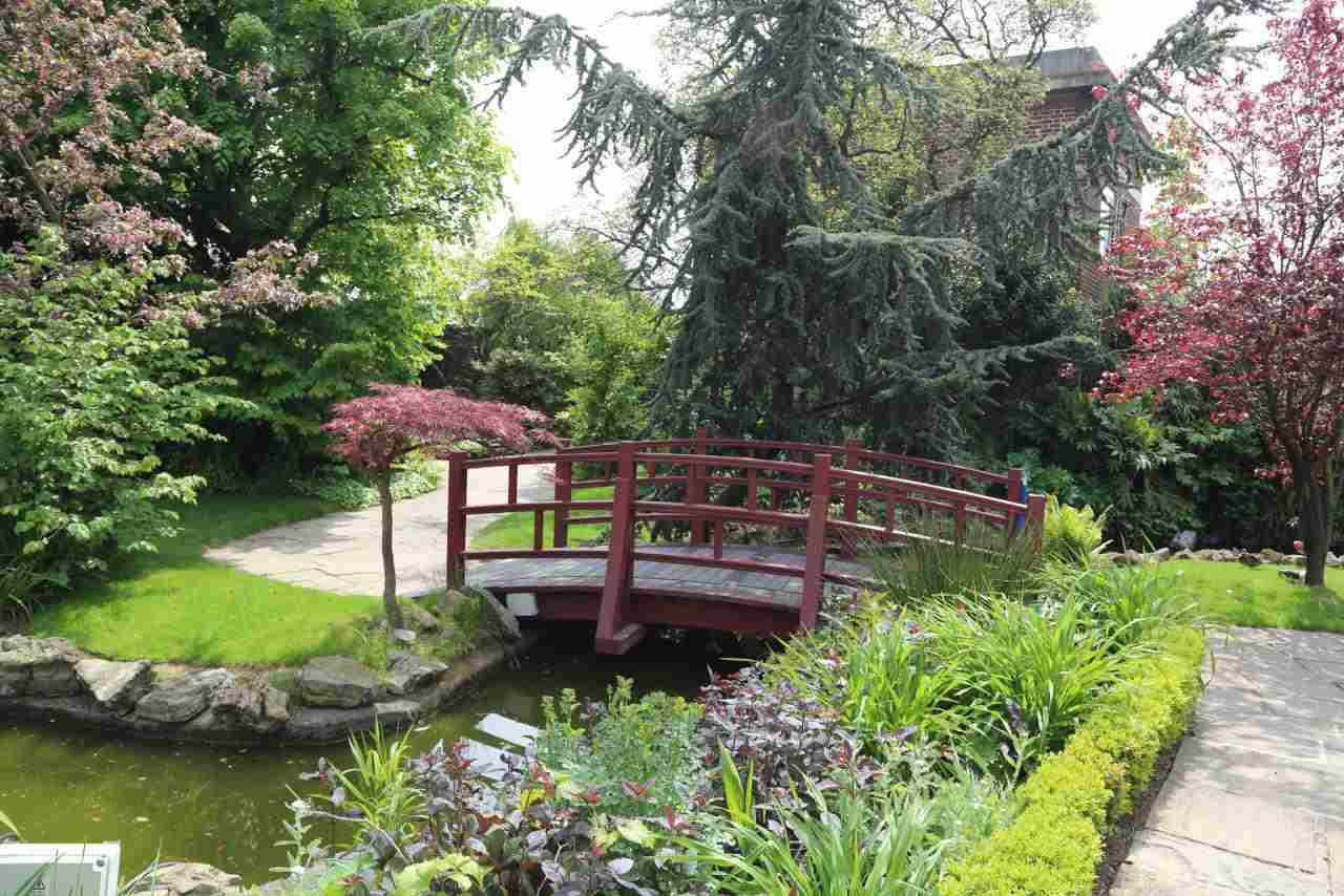japanischer Garten anlegen Ideen Brücke Holz Teich Rasenfläche