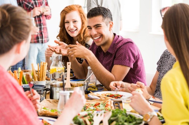 junge menschen vegetarier werden auf dem tisch it pflanzlichen lebensmitteln lachend