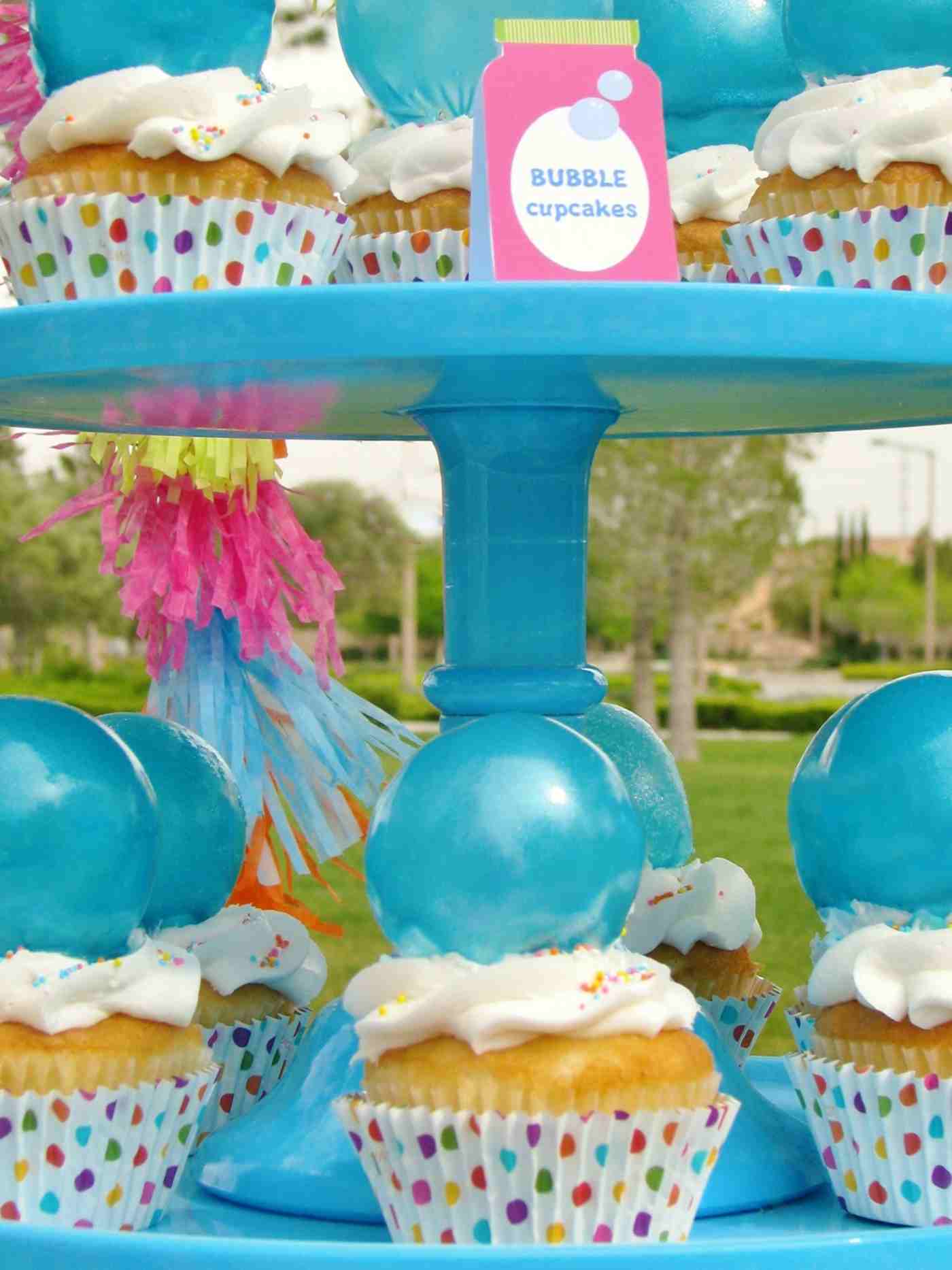 Blue bubbles and dotted objects decorate the cupcakes for a party