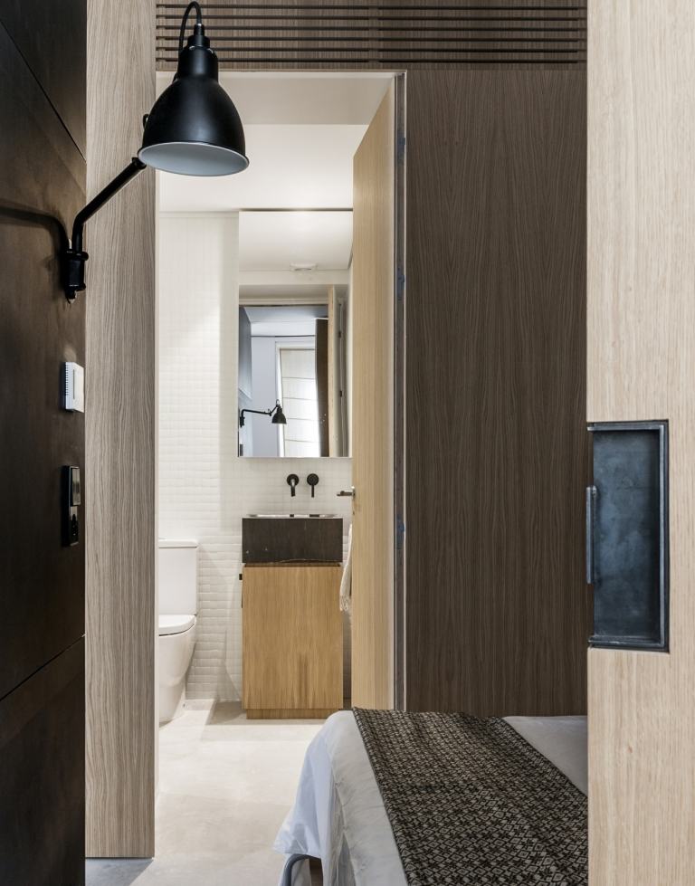 Eine Holz Trennwand mit eingebauter Tür trennt das Gästezimmer vom Gäste-WC und Bad
