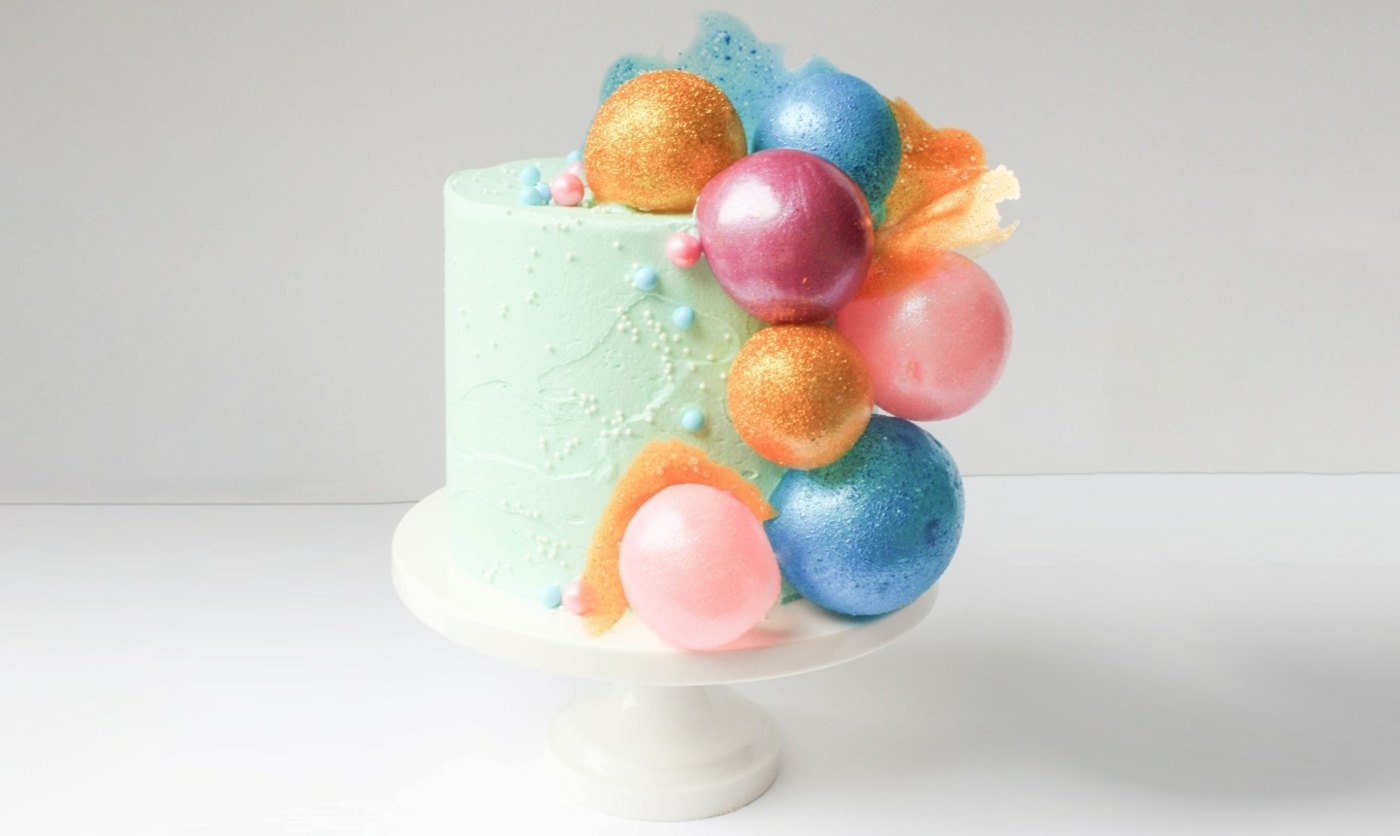 Gelatin balls with glitter effect as decoration on a small cake