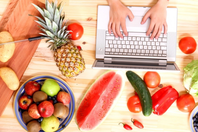 essen im sommer aus ananas wassermelone und anderes obst und gemüse während arbeiten am laptop