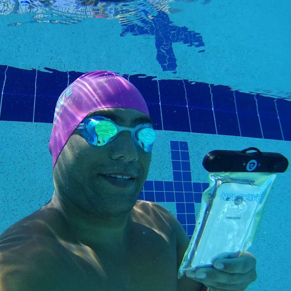 mann im pool mit wasserdichte handytasche und taucherbrille macht foto unter dem wasser