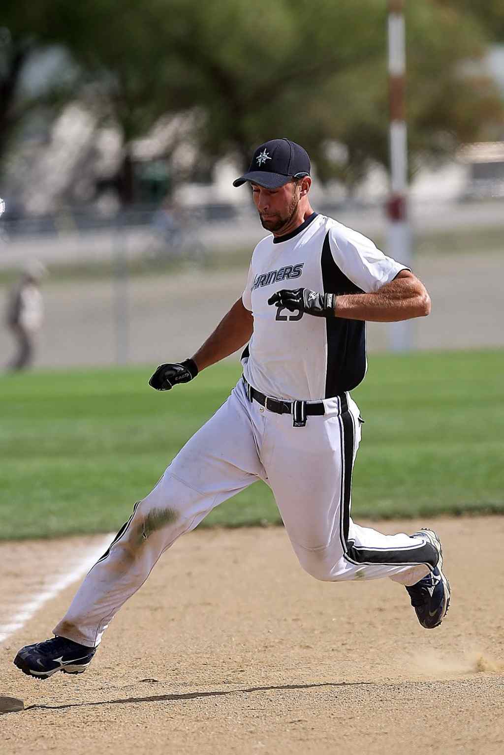 sportler trägt baseballkappe mit weißer sportbekleidung auf dem sportfeld