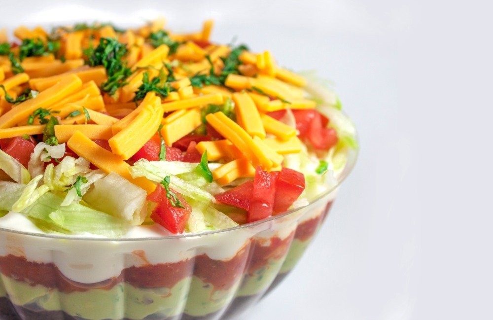 8 layers of mexican salad with carrot bell pepper iceberg lettuce and avocado dressing