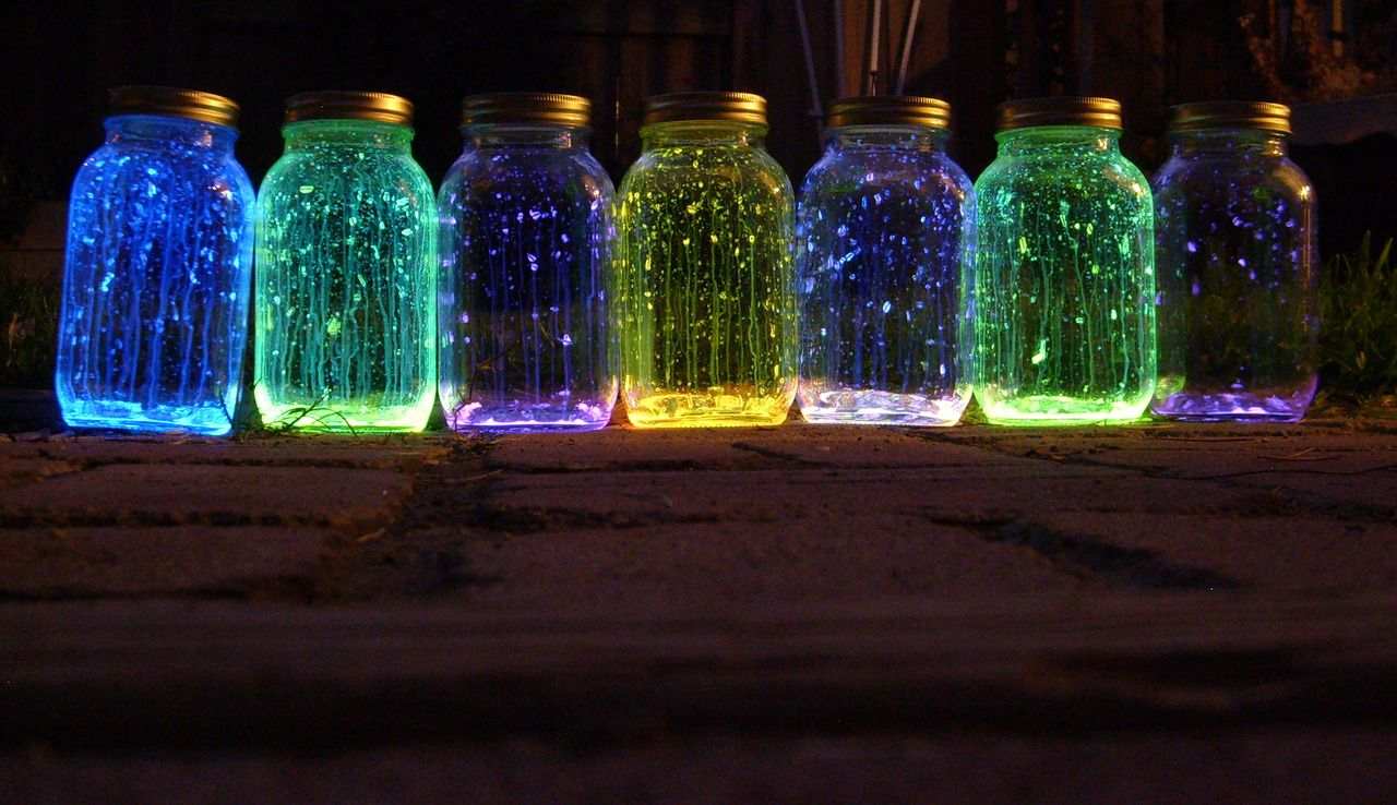 Schöne Leuchtgläser mit Leuchtfarbe in verschiedenen Farben für drinnen und draußen