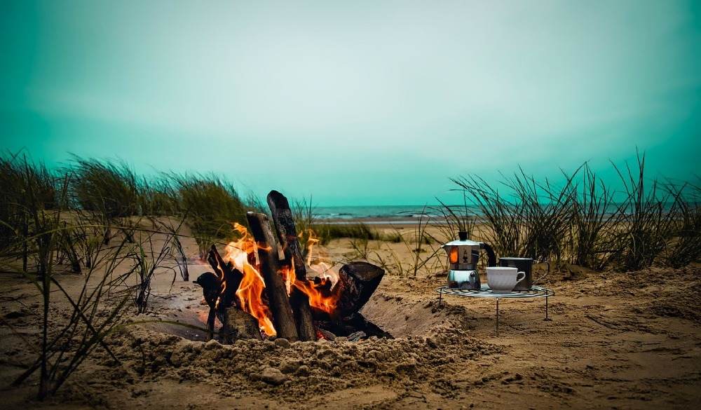 brennendes lagerfeuer rezepte am strand mit kaffee und grillrost camping kochen
