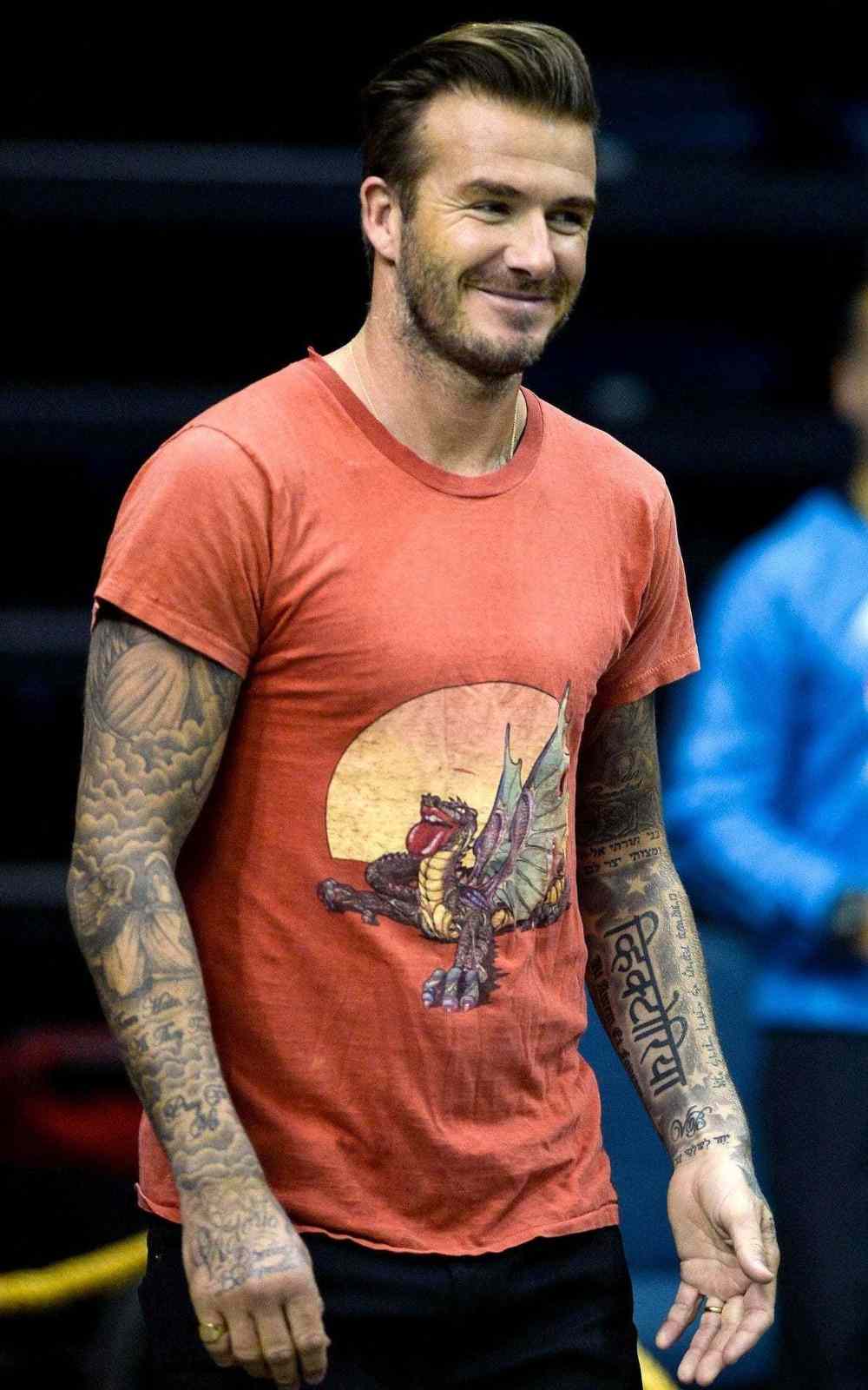 david beckham mit tattoos an beiden ärmen und t-shirt lächelt