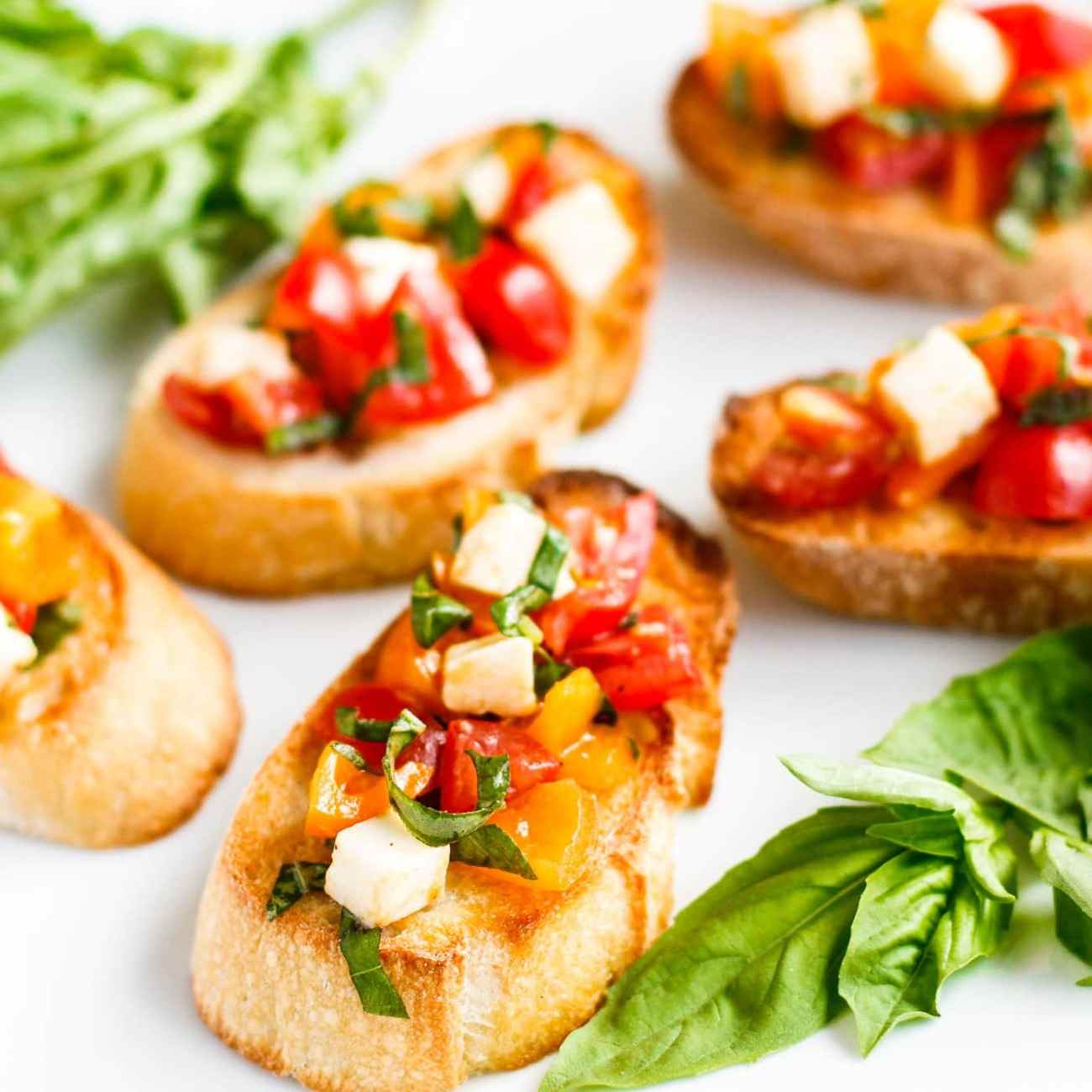 simple finger food recipes for bruschetta with cherry tomatoes and mozzarella garnish with basil leaves
