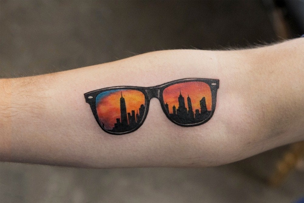 colorful sunglasses tattoo and forearm with skyscrapers and sky
