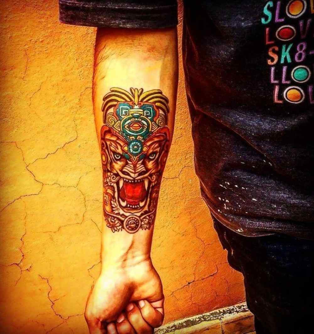 großartiges tattoo design mit vielen farben und symbolik für unterarm