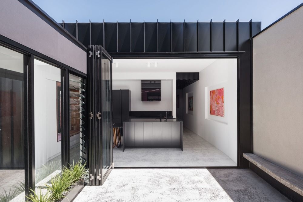 courtyard and transition to modern kitchen with kitchen island and glass sliding doors