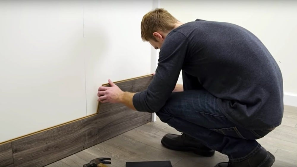 young man sticking laminate parts in the wall