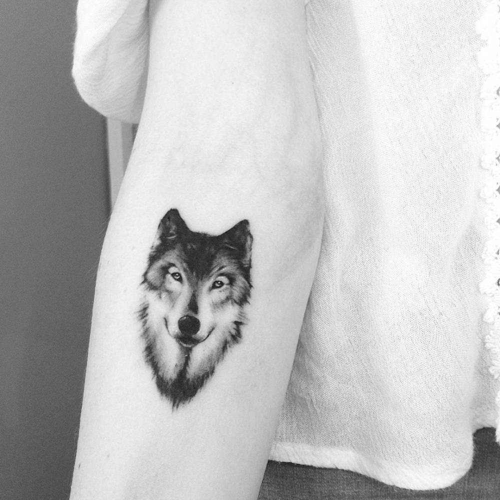 kleines wolf tattoo in schwarz weiss auf der unterarm tätowieren lassen als seeletier totem