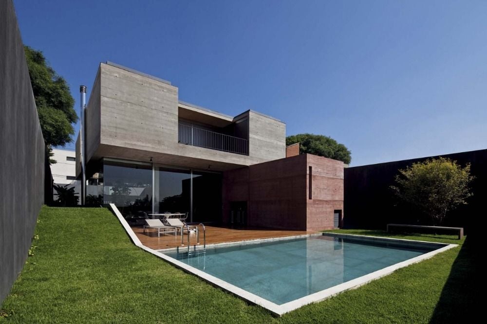 combination of gray concrete paints with red accents for home with pool and garden