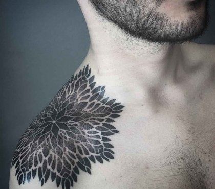 mann mit floralem muster tattoo an der schulter mit schwarzer tintenfarbe tätowiert
