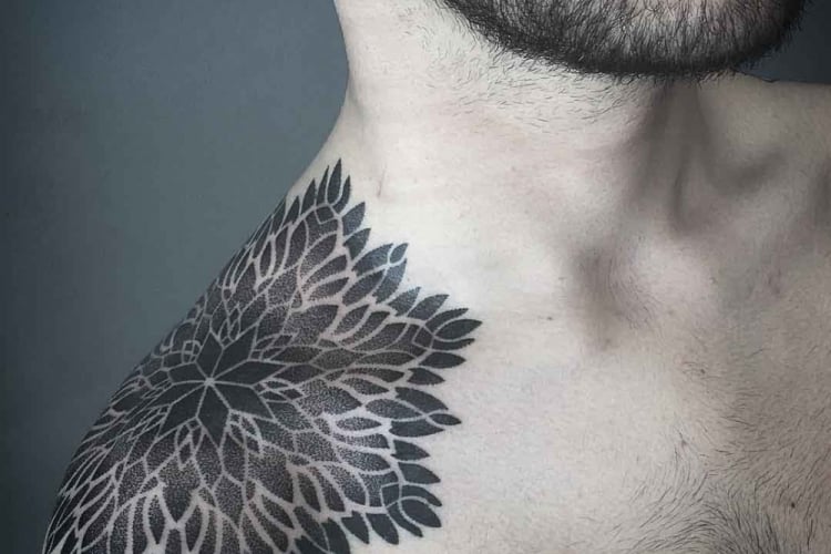 mann mit floralem muster tattoo an der schulter mit schwarzer tintenfarbe tätowiert