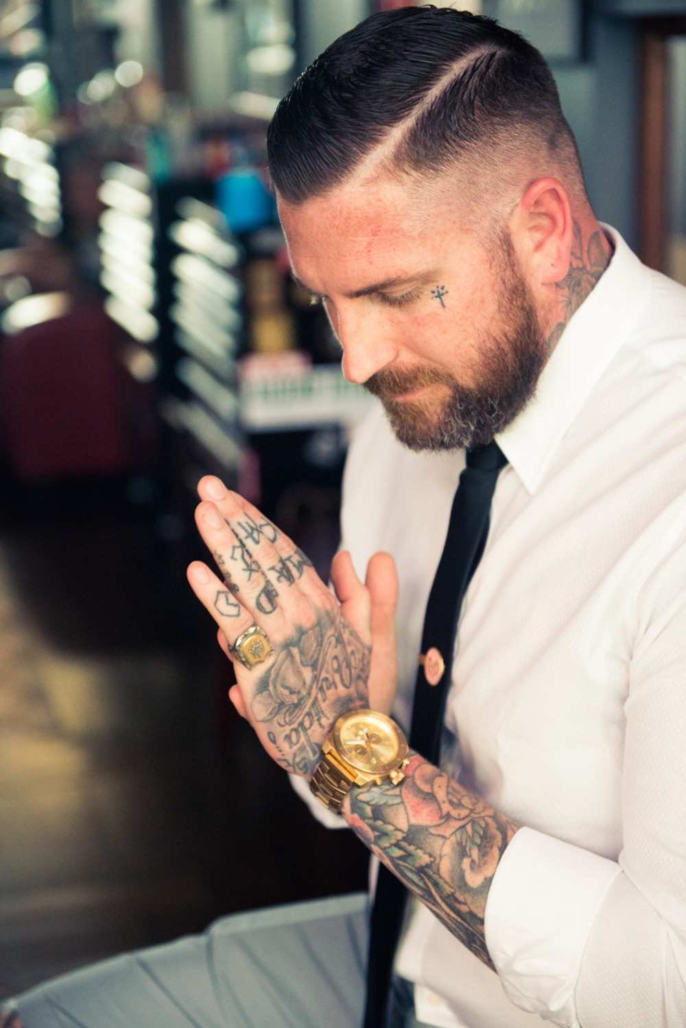 tattoo klein mann am gesicht kreuz tätowierung und ärmel tattoos an fingern