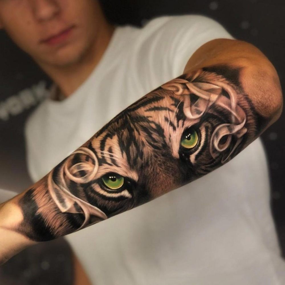 tiger tattoo mit grünen augen auf außenseite des arms von mann