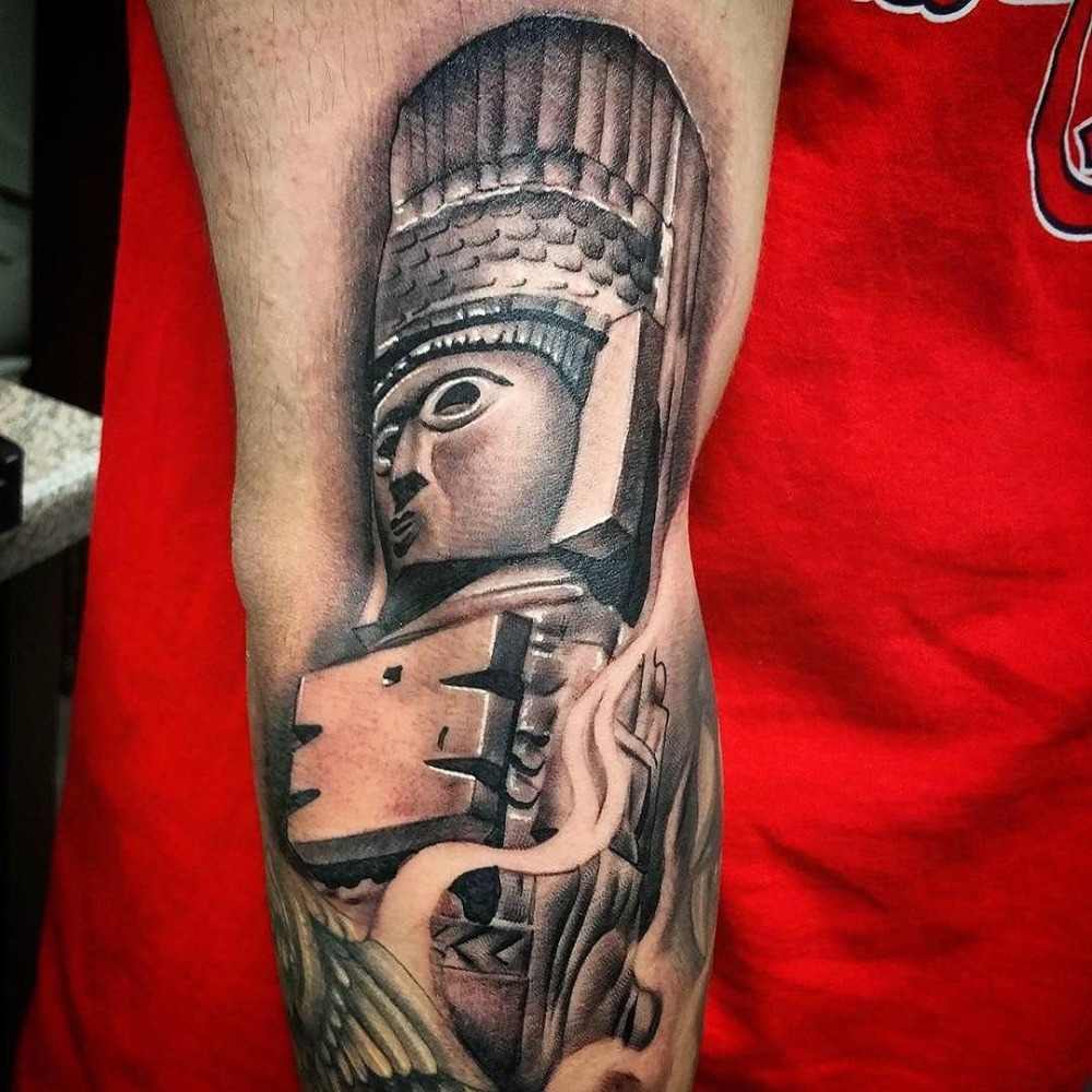 totem figure from ancient times as maya tattoo upper arm
