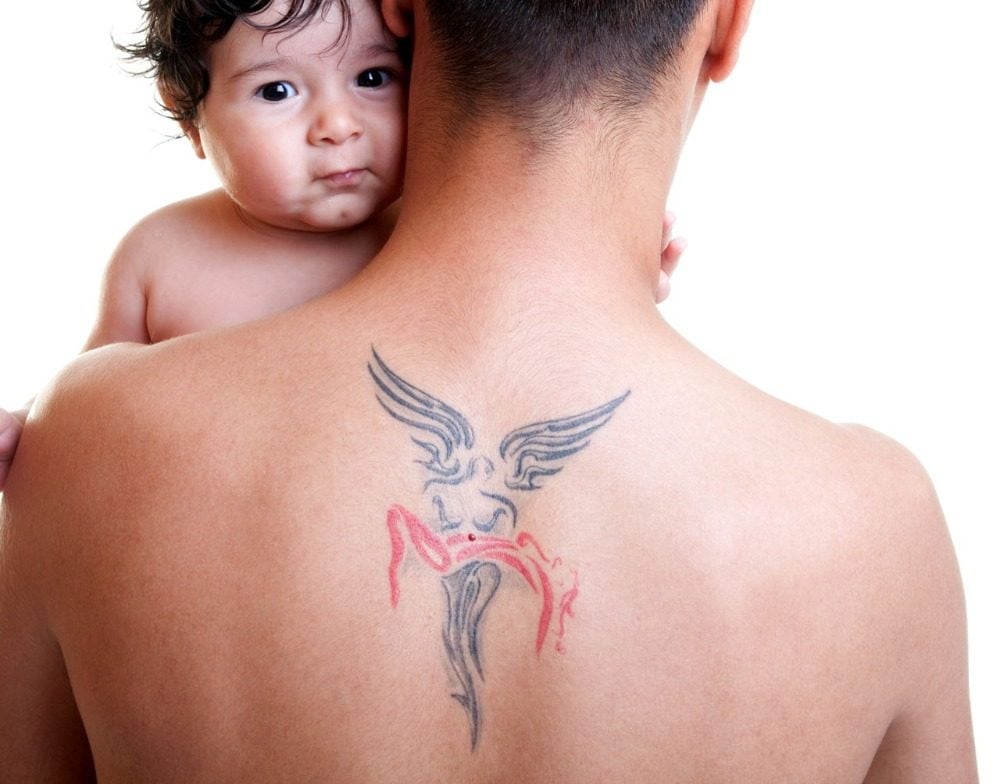 father with back tattoo angel thematically keeps his child