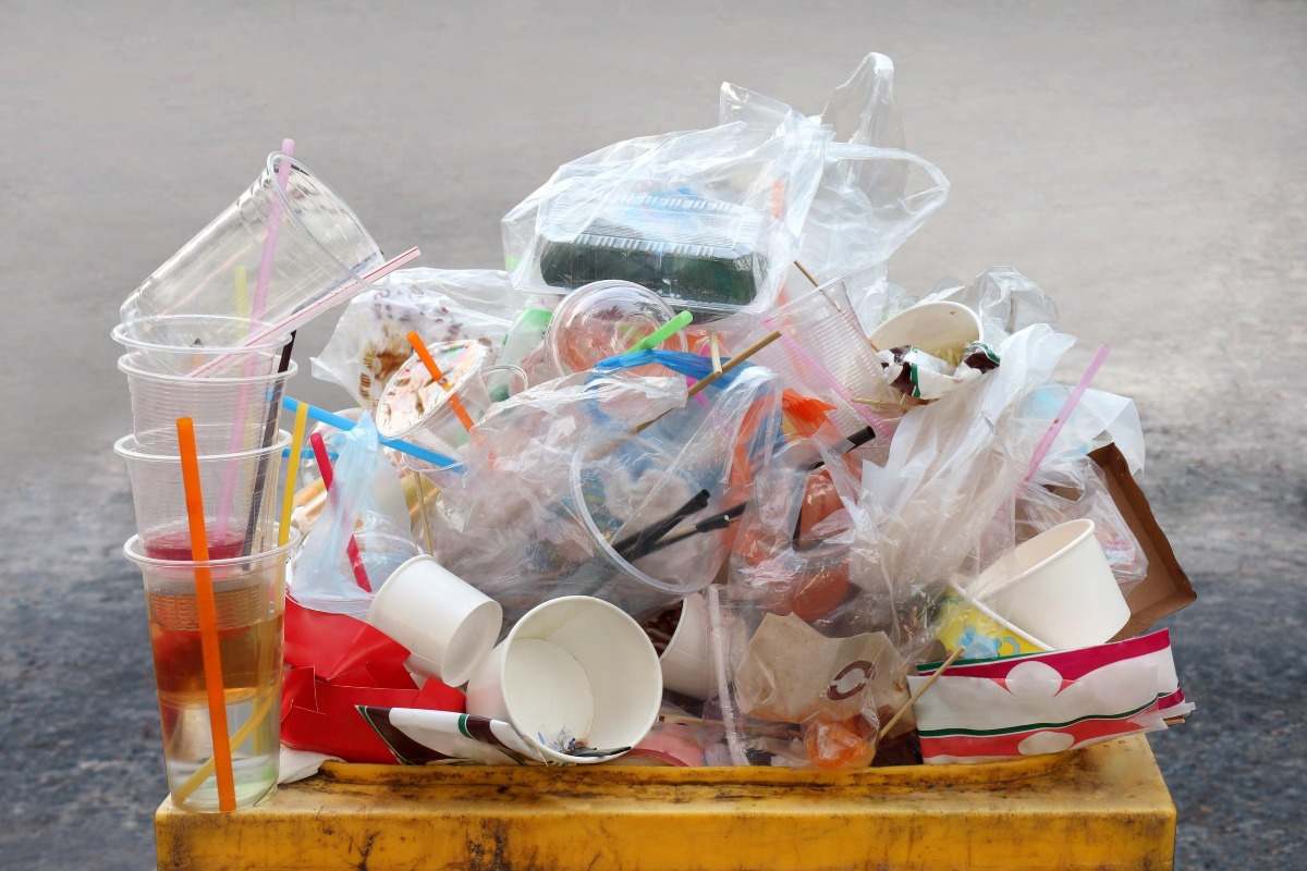 various plastic and plastic products such as solid plastic containers standing in the garbage bin