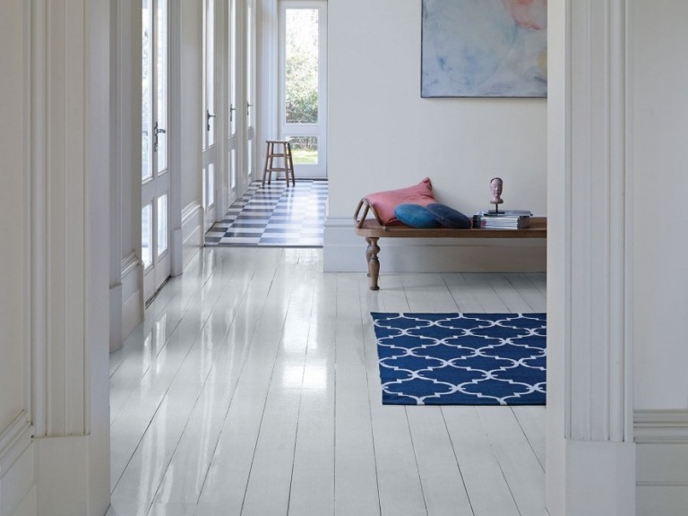 Altweiße Wände und dunkelblauer Teppich im Flur im skandinavischen Stil