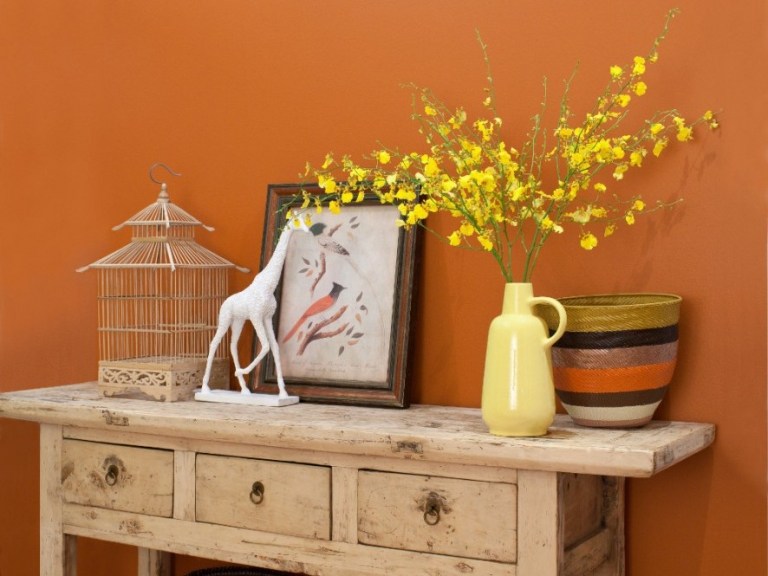 Orange Wand und vintage Shabby Schick Einrichtung gelbe Porzellanvase und Vogelkäfig und Rattankorb als Dekoration