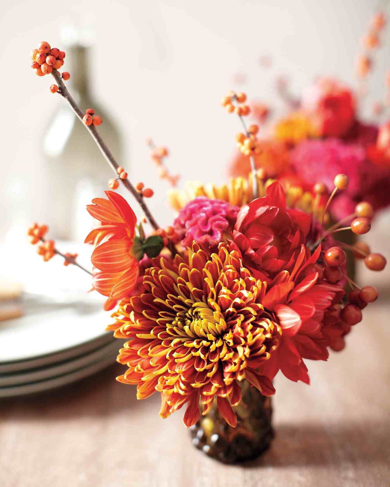Herbstdeko mit Chrysanthemen und Dahlien in kleiner Vase oder Marmeladenglas 