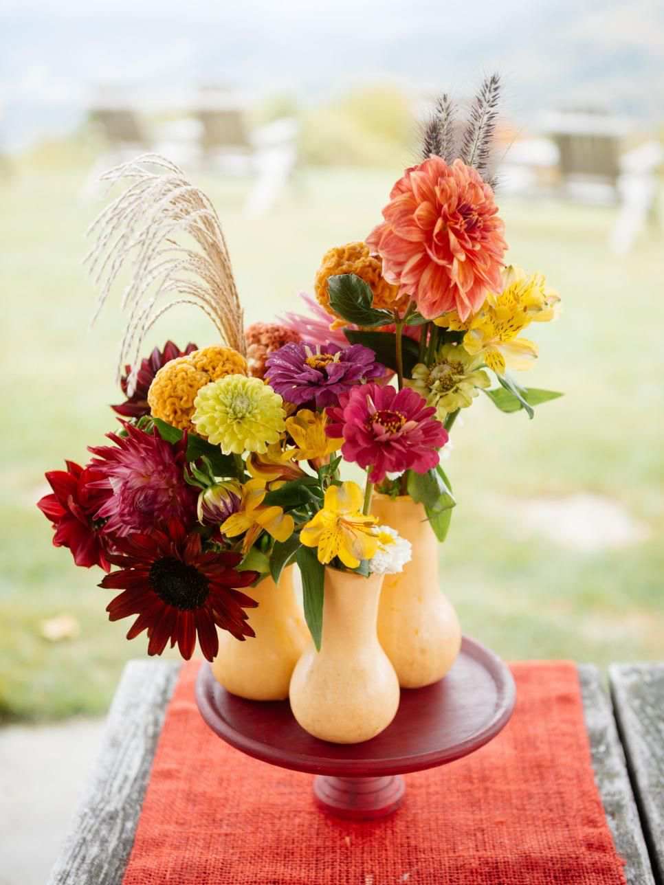 Autumn table decoration with Dahlien flower sticks in pumpkins arranging ideas for decoration for the dinner party