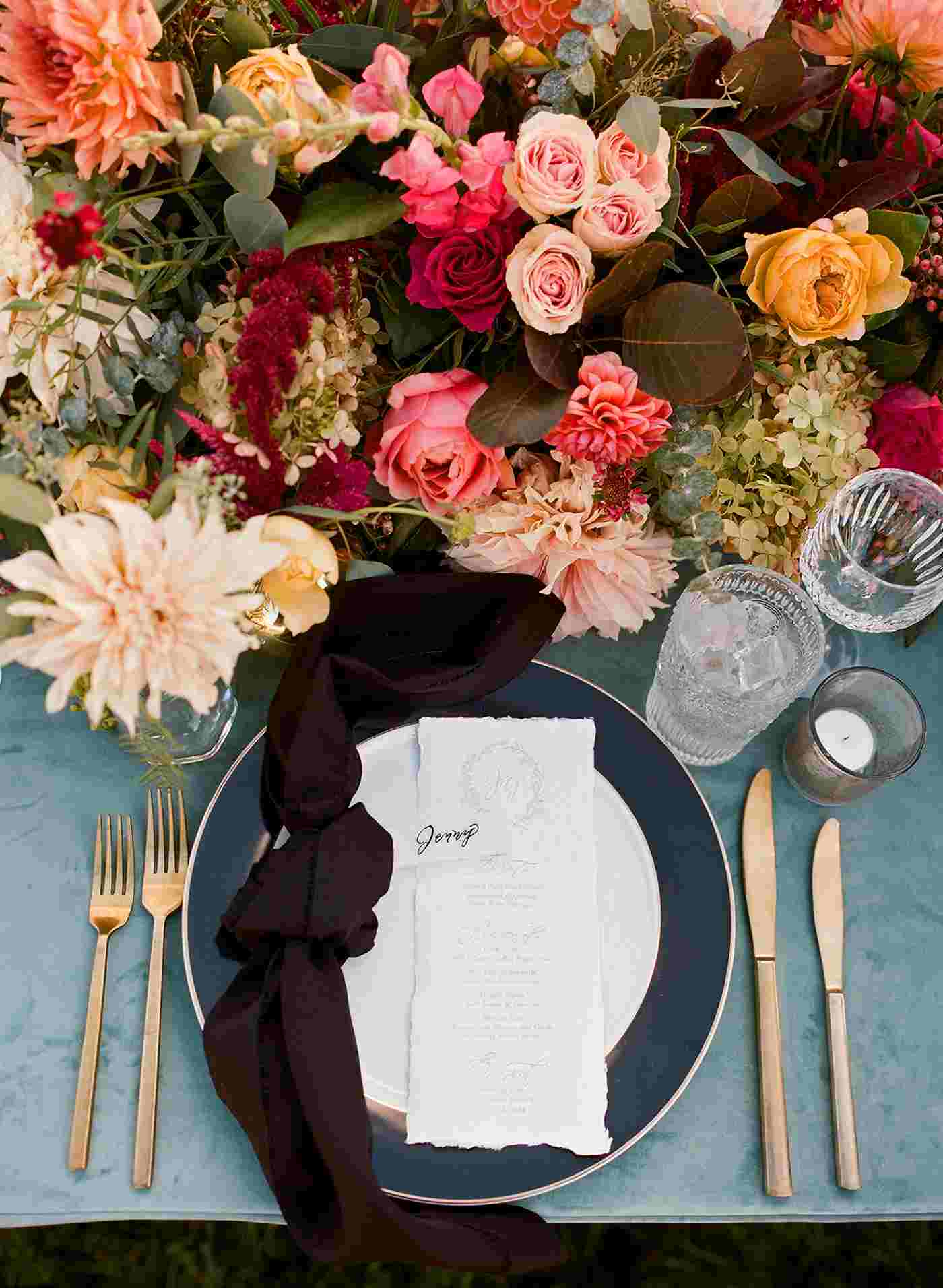 Autumn table decoration with roses and dahlias and autumn leaves and ornamental grasses