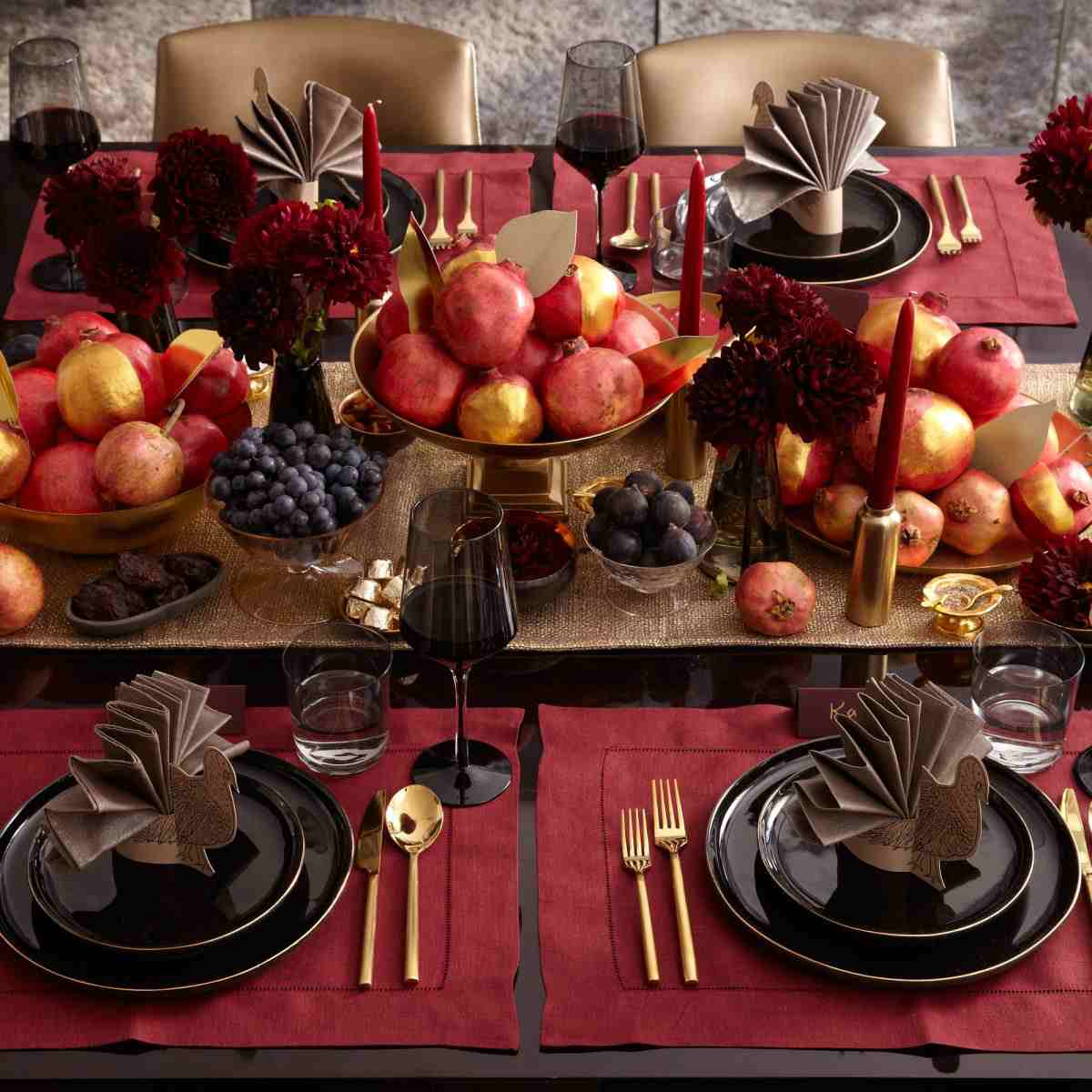 Autumnal table decoration with red rotten dahlias and gold-painted fruits and wine grape and beautifully folded napkins