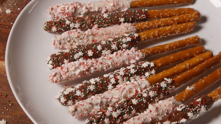 Süßigkeiten zu Weihnachten backen Salzstangen mit Streudeko verzieren und weißer Schokolade übergießen