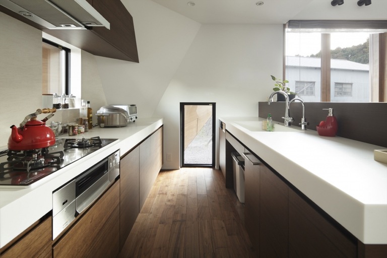 Moderne Küche unter Dachschräge gestalten Grifflose Holzfronten und weiße Arbeitsplatte 