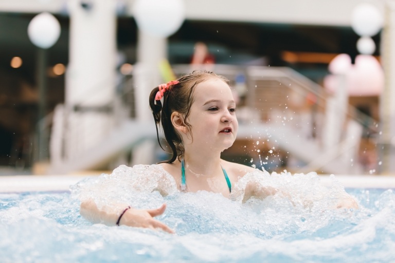 Spaß im Sprudelwasser Kinder im modernen Whirlpool für drei 