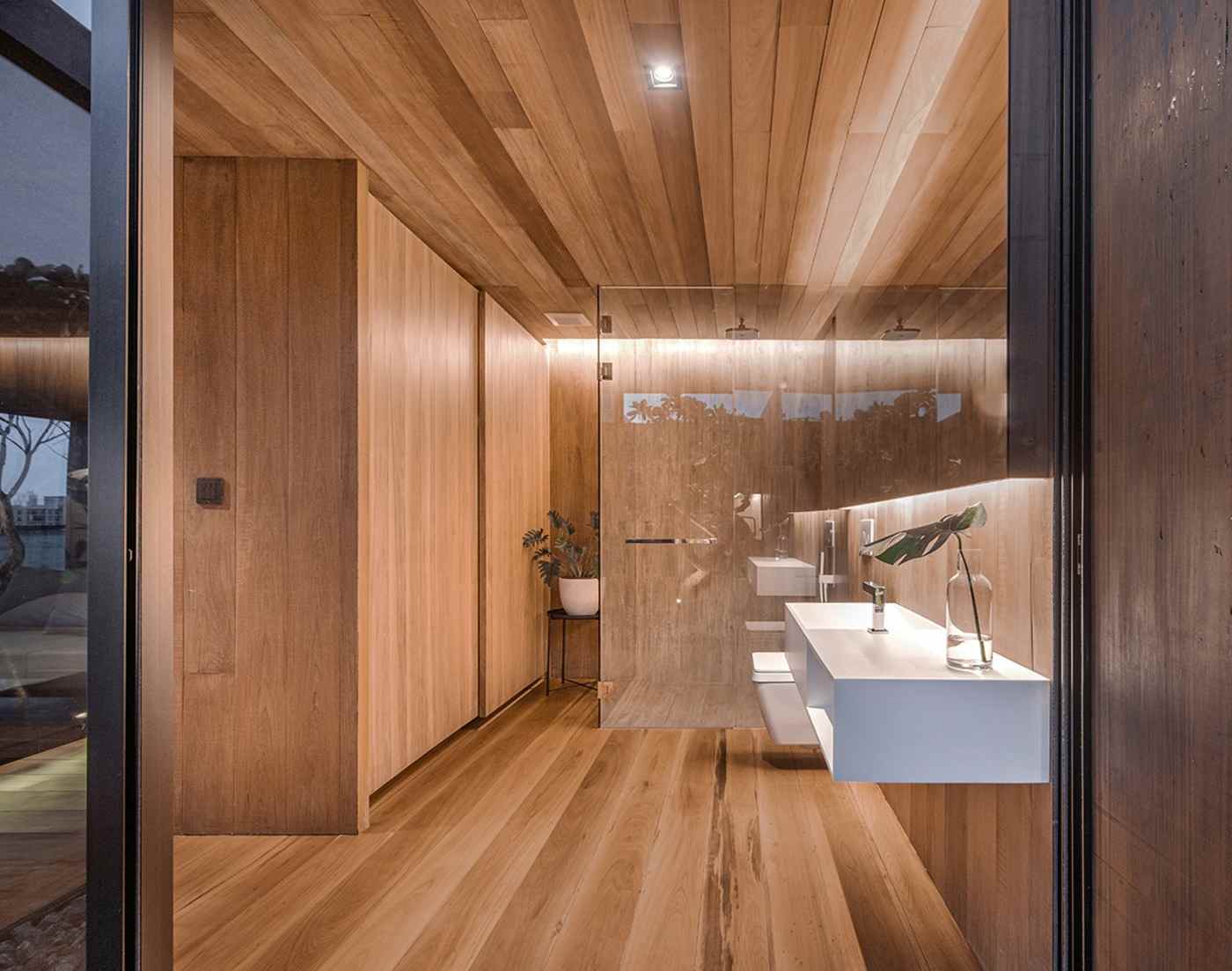 bath made of wood with splash wall for shower and white wash basin