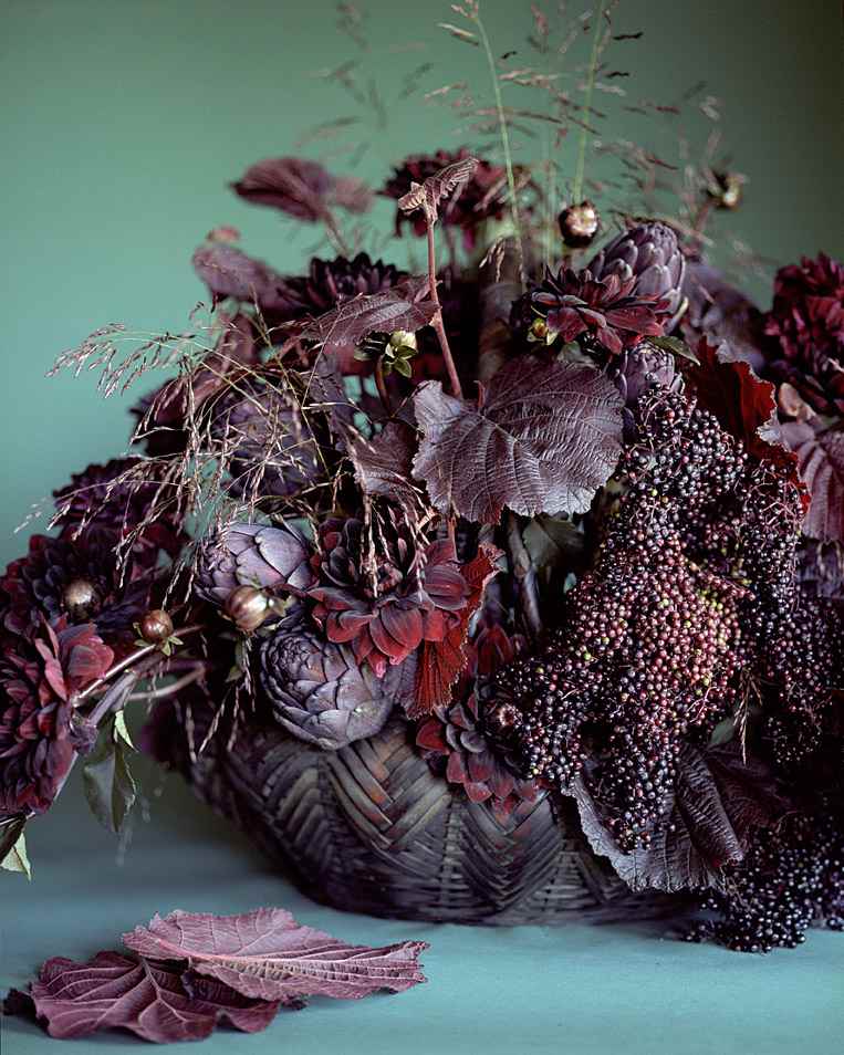  Herbstliche Tischdeko in Dunkelbraun perfekt zum Halloween oder Erntedankfest braun gefärbte Hasel Blätter und Rispenhirse und rote Ziergräser und schwarze Dahlien und lila Artischocken